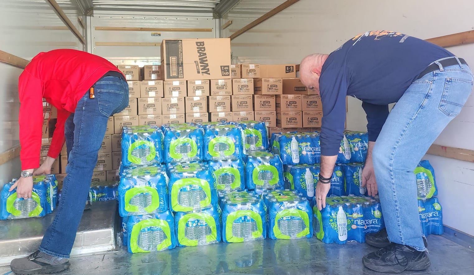 Volunteers unload a truck with water for residents of New Palestine, OH on Feb 18, 2023